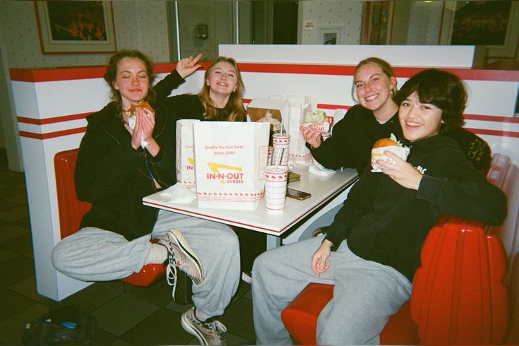 Four friends together in an In-N-Out booth, photographed with direct flash.
