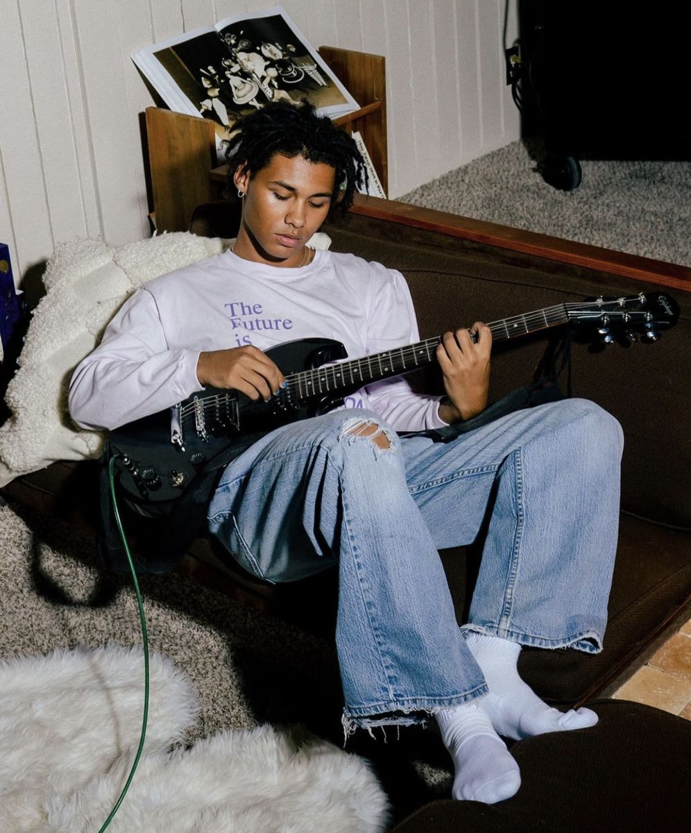 Mood reference: a young guitarist practicing on a sofa.